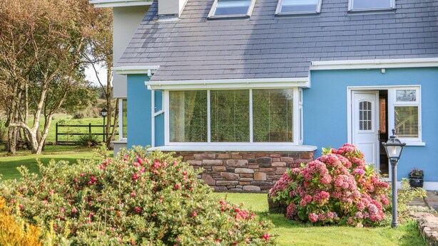 A house with a stone foundation, a grey roof, and a blue exterior. - The Blue Annex (Tralee)
