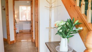 A hallway with wooden flooring, a white radiator, and a window with blinds. - The Blue Annex (Tralee)