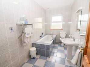 A modern bathroom with a bathtub, toilet, and sink. - Reads Park (Galbally)