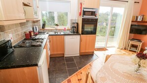 Une cuisine moderne avec des meubles en bois, un lave-vaisselle, un four à micro-ondes et une grande fenêtre donnant sur l’extérieur.