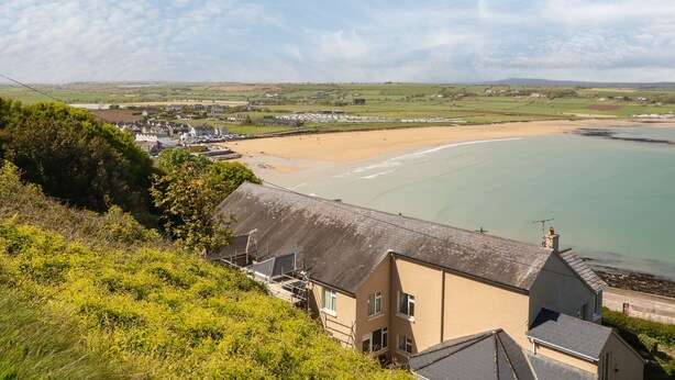 A coastal town with a sandy beach, houses, and greenery. - Island View (Ardmore)