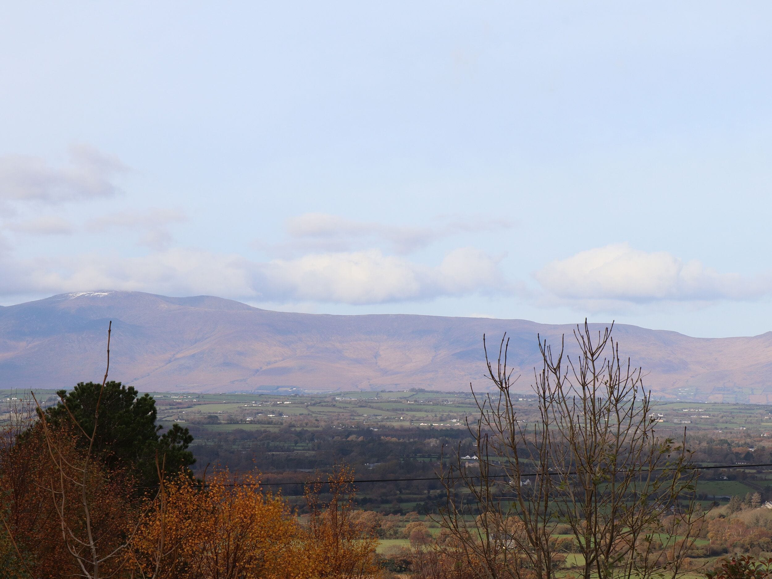 A mountainous landscape with a clear sky and a view of a valley below.
