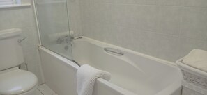 Uma casa de banho com sanita, cabine de duche e banheira.