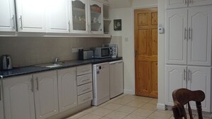 A kitchen with white cabinets, a microwave, and a dishwasher.