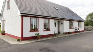 A white building with red trim and a grey roof. - Lough Mask Road Fishing Lodge (Cong)