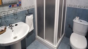 A bathroom with a shower enclosure, a sink, and a toilet. - Hostal Talavera (Talavera la Real)