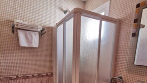 A bathroom with a toilet, a shower enclosure, and a sink. - Hostal Talavera (Talavera la Real)