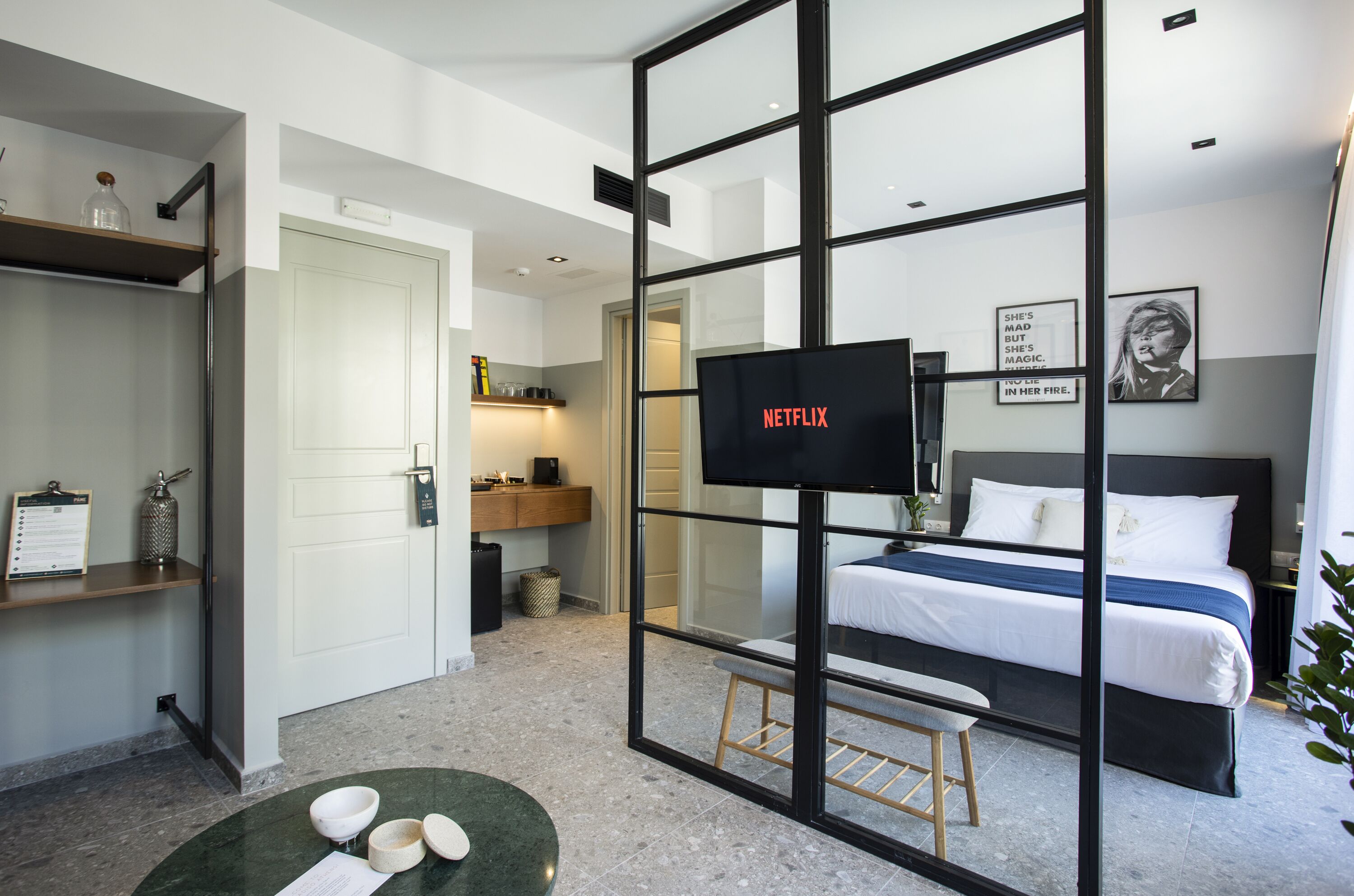 Een moderne hotelkamer met een groot bed, een televisie, een bureau en een zithoekje.
