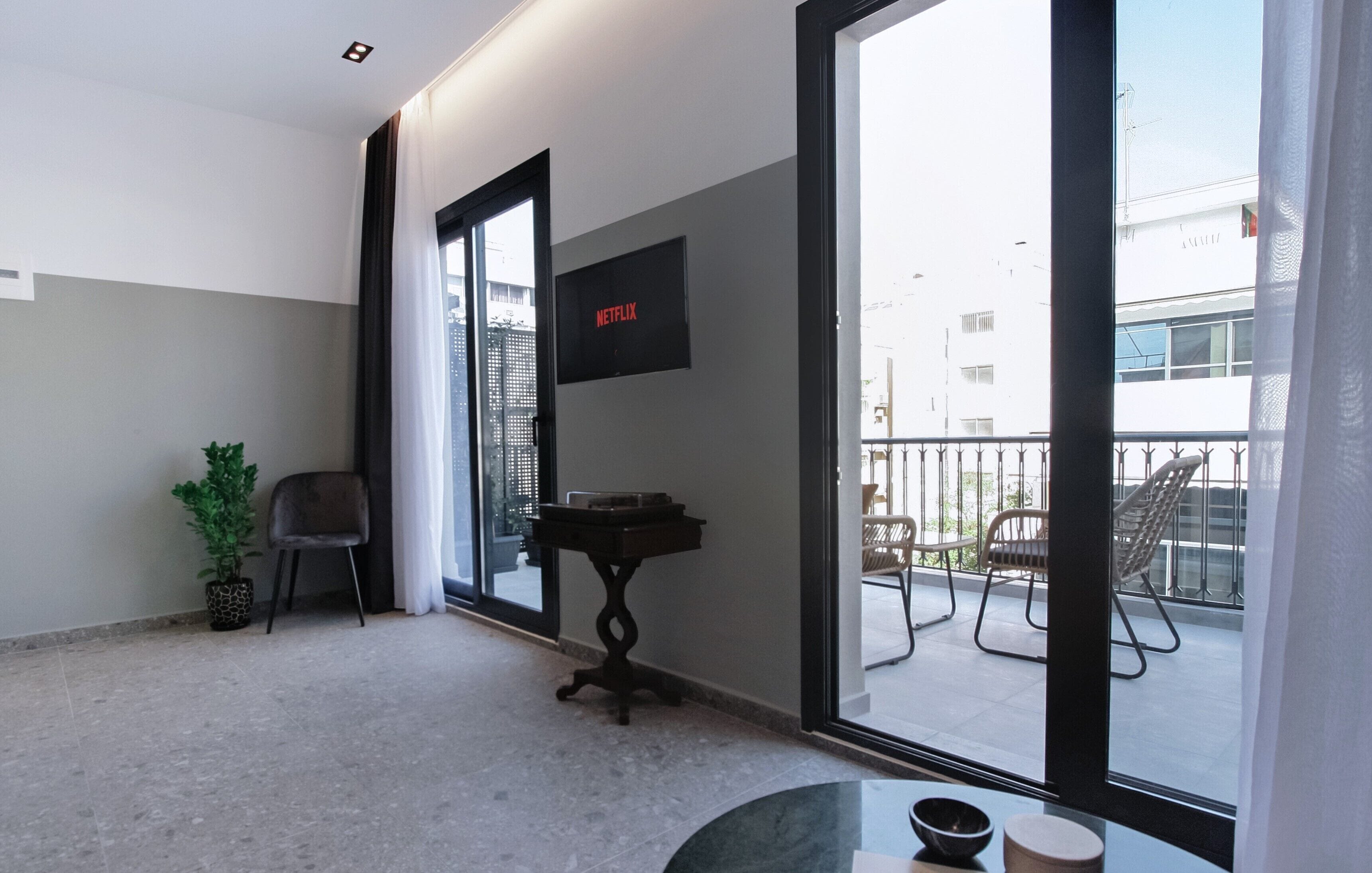 Ein Balkon mit Blick auf die Stadt, ein Tisch mit einer Schale, ein Stuhl und ein kleiner Tisch mit einem Tablett.