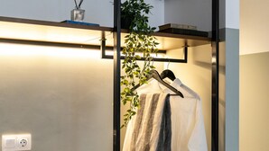 A compact room with a bed, bedside table, and a hanging plant. - Pame Paradiso (Athens)
