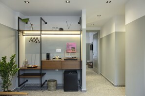 A modern bathroom with a wooden vanity, a black trash bin, and a small potted plant.