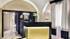 Uma área de recepção com balcão preto, detalhe dourado e uma placa com a inscrição 'citykey'.