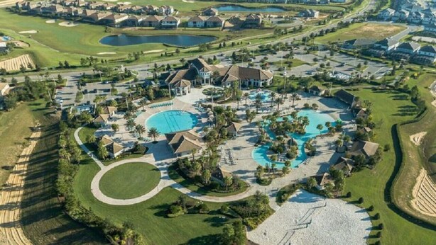 Oversigtsbillede af et resort med flere swimmingpools, golfbaner og boligbygninger.