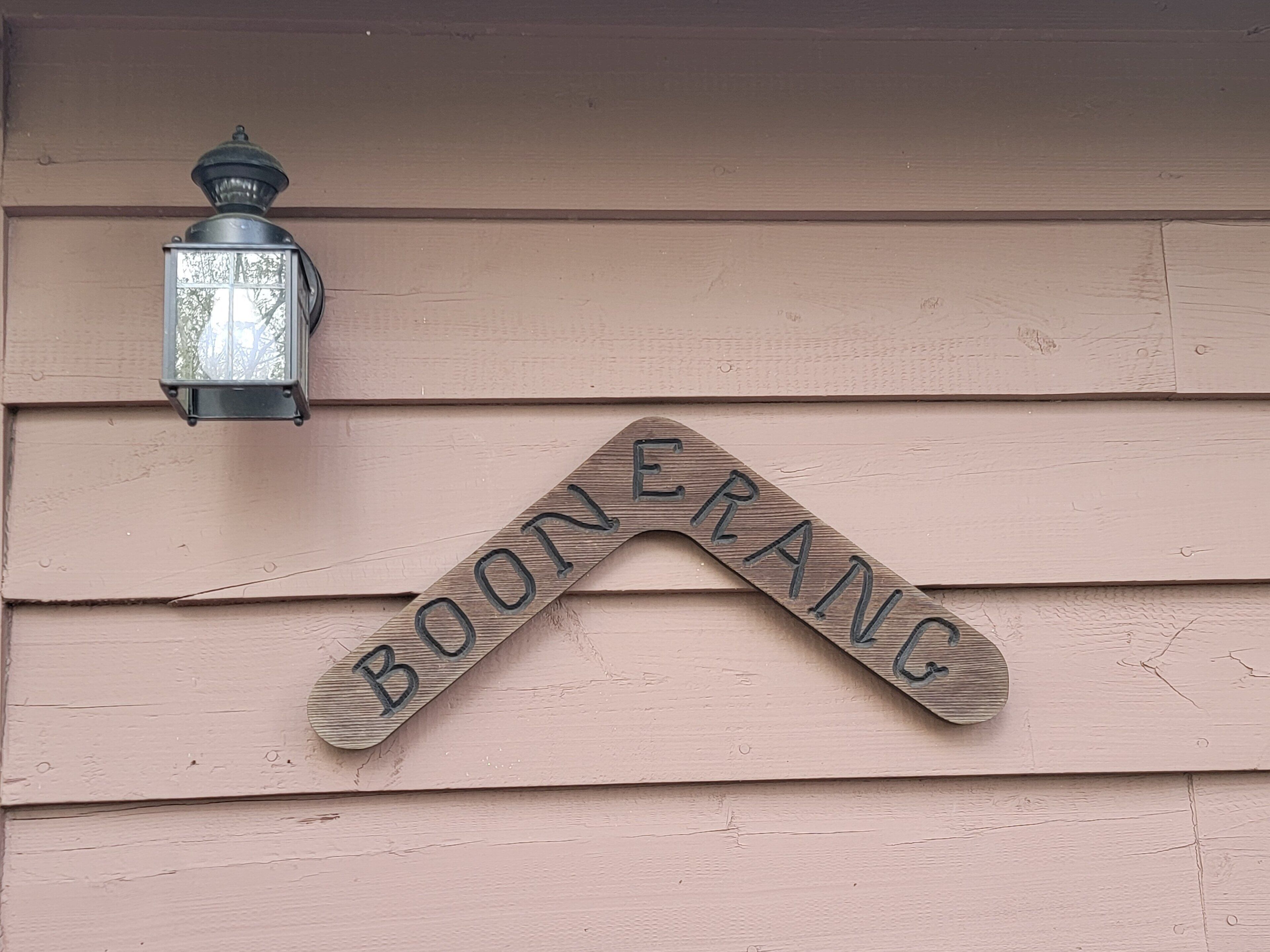 A wooden sign with the text "BOONERANG" mounted on a house.