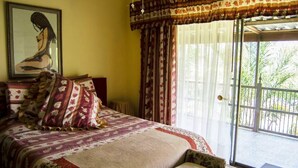 A bedroom with a large bed, a framed picture on the wall, and a view of the outdoors through a sliding glass door. - Comfit Zone B&B (Newcastle)