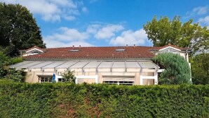 Un bâtiment à deux étages, doté d’un toit plat, de grandes fenêtres et d’un garage.