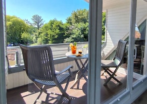 A balcony with two chairs, a table, and a drink. - Apartment Rosenhof 10 - Wh. 10 (Kühlungsborn)