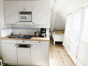 A compact kitchen with a microwave, coffee maker, and sink. - Apartment Rosenhof 10 - Wh. 10 (Kühlungsborn)