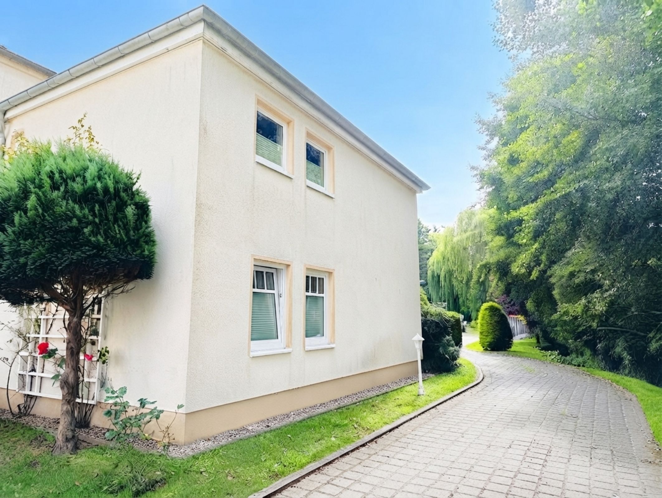 A two-story building with a paved driveway and a well-maintained lawn.