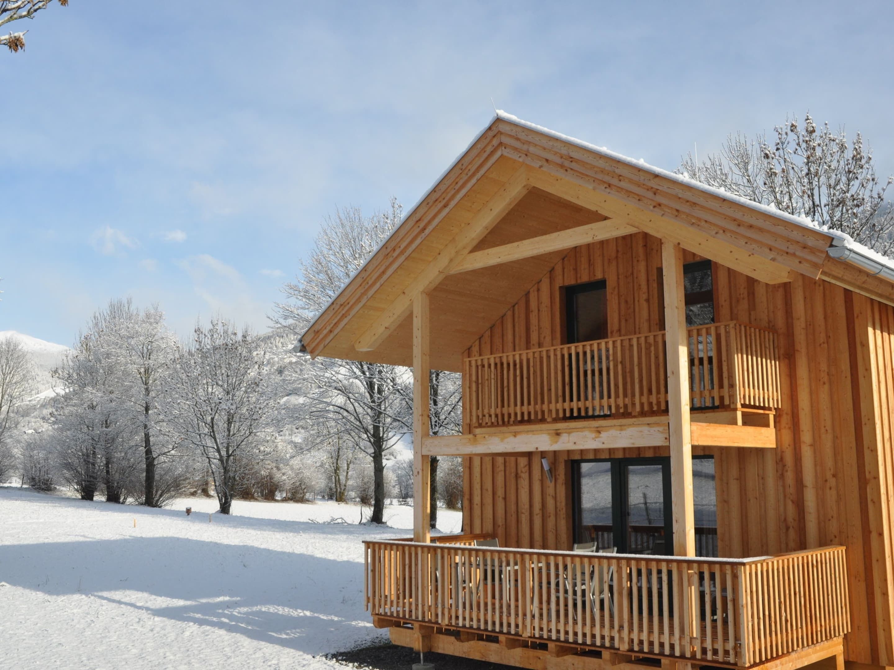 Eine Holzdiele mit Balkon, eingebettet in eine verschneite Landschaft.