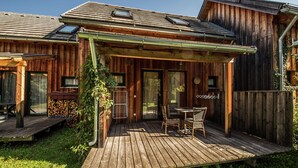 A wooden cabin with a deck, outdoor seating, and a covered patio area. - Spacious Chalet near Ski Area in Sankt Georgen ob Murau (Sankt Georgen am Kreischberg)