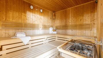 A sauna with wooden benches and a stone heating system.