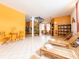 A hotel lobby with wooden furniture, a staircase, and a reception area.