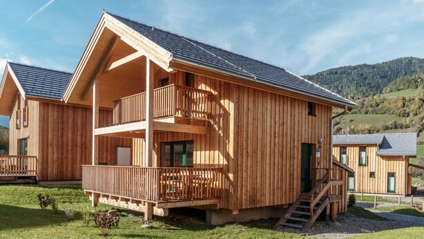 A wooden chalet with a balcony, a staircase, and a view of the surrounding landscape. - Snug Chalet With Sauna (Sankt Georgen am Kreischberg)