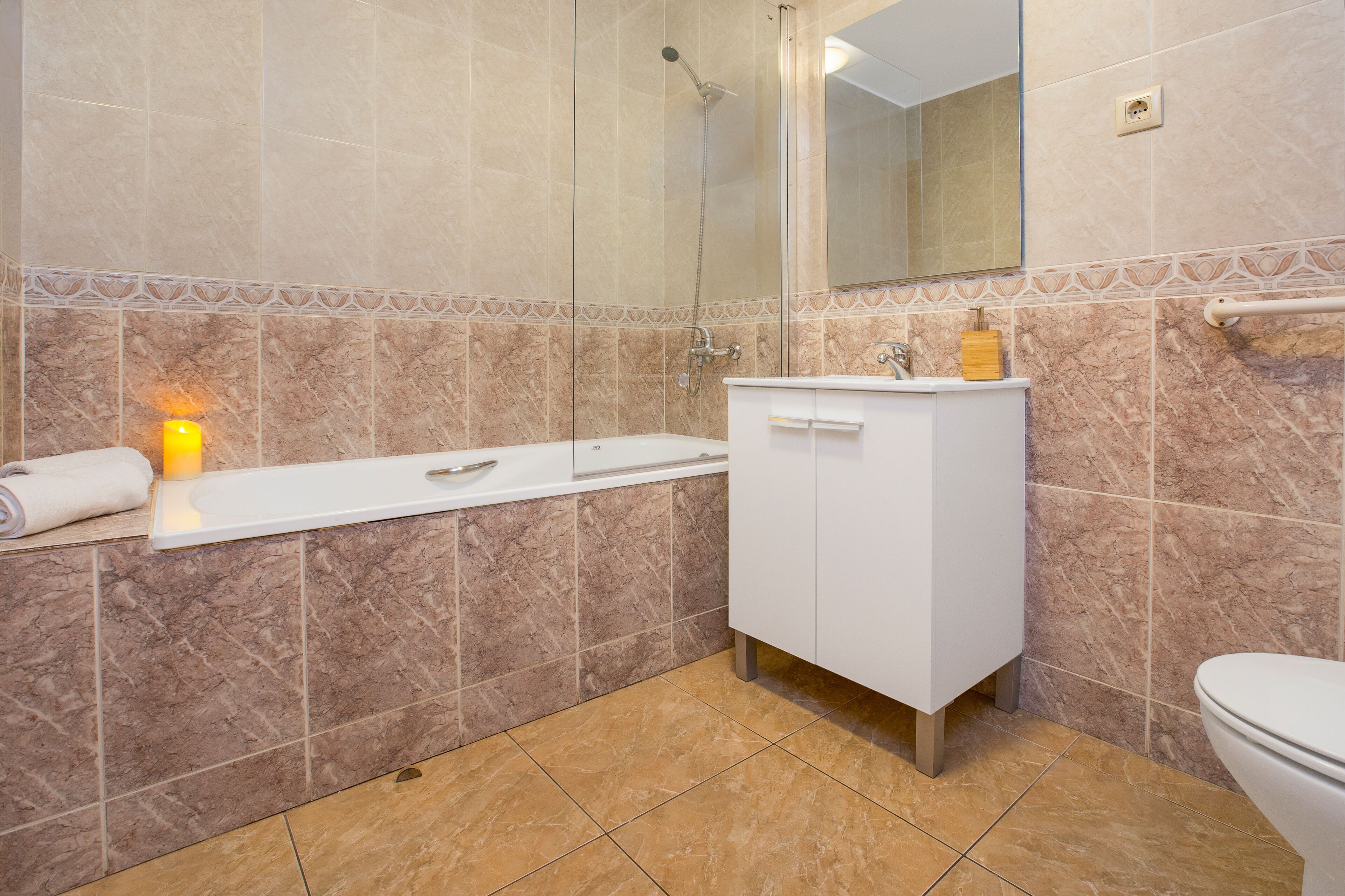A bathroom with a white sink, mirror, and toilet.