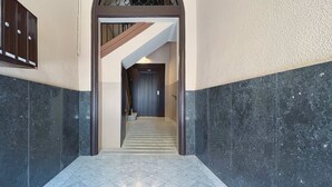 A hallway with a marble floor leading to a staircase. - Stay U-nique Apartments Casanova (Barcelona)