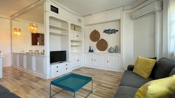 Een woonkamer met een televisie, bank en salontafel.