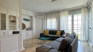 Een woonkamer met een bank, een bijzettafeltje en een kast.