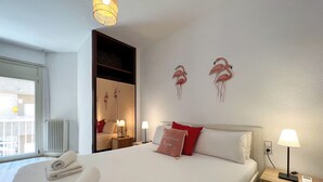 Een hotelkamer met een groot bed, twee bedlampen, een nachtkastje, een spiegel en een raam met uitzicht.