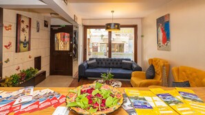 A hotel lobby with a sofa, a dining table with brochures, a decorative vase, and a painting on the wall. - Opera House Hotel (Istanbul)