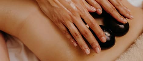 Gros plan sur des mains effectuant un massage sur le dos d’une personne.