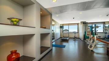 A gym with exercise equipment, a treadmill, and a large window.