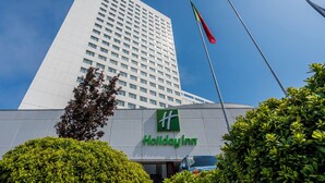 A Holiday Inn hotel building with a clear sky and a flag. - Gaia Residence (Vila Nova de Gaia)