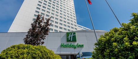 Edifício do hotel Holiday Inn sob um céu claro com uma bandeira.