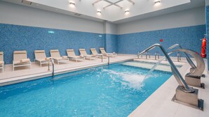 A swimming pool with lounge chairs and a clear ceiling. - Gaia Residence (Vila Nova de Gaia)