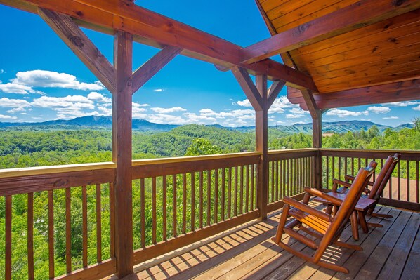 Une terrasse en bois offrant une vue sur un paysage montagneux.