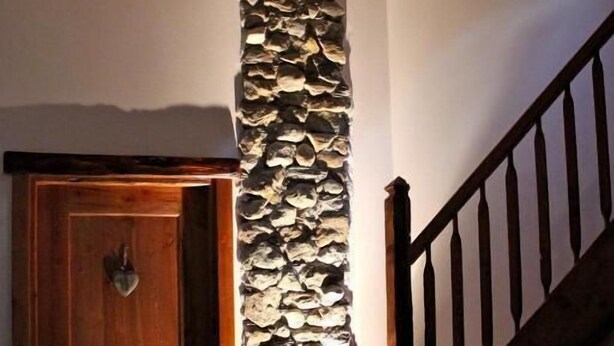 A wooden door, a stone wall, and a staircase with a wooden railing. - B&B Il Mortirolo (Mazzo di Valtellina)