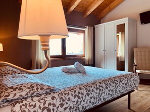 Une chambre à coucher avec un lit, une lampe de chevet, une armoire et une chaise.