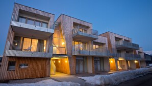 Een modern meerlaags gebouw met balkons en grote ramen.