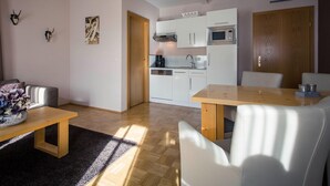 A modern apartment with a kitchen, dining area, and living room. - Cozy Apartment near Ski Area in Turracherhohe (Stadl-Predlitz)