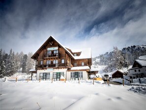 En stor träbyggnad med flera balkonger och en skylt som visar att det är ett bostadshus.