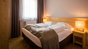 A neatly made bed with white linens, a wooden headboard, and a bedside table with a lamp. - Studio Apartment on Turracherhohe Near Lake (Stadl-Predlitz)