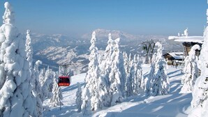 A snow-covered mountain landscape with a ski lift and buildings. - Fabulous Mansion in Haus im Ennstal near Ski Area (Aich)