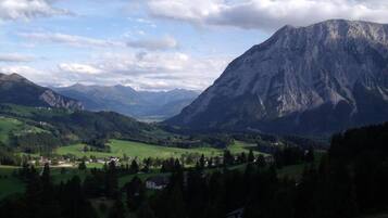 A mountainous landscape with a valley, houses, and a prominent mountain peak.