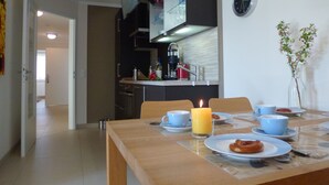 A dining area with a table set for breakfast, including plates, cups, and a candle. - Bright apartment with elevator, wellness area, fitness, sauna, families, WiFi (Niendorf)