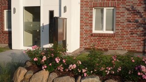 A brick building with a white door and window blinds. - Bright apartment with elevator, wellness area, fitness, sauna, families, WiFi (Niendorf)